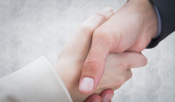 Close up on new partners shaking hands against white background
