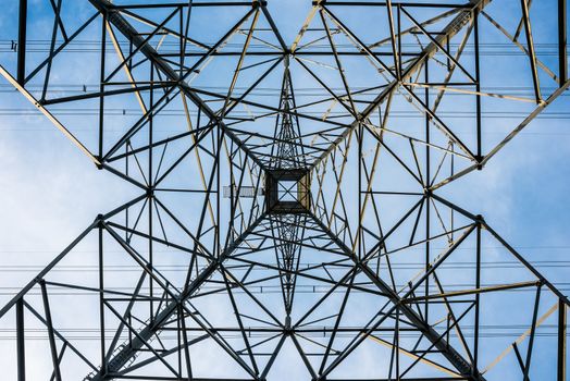 Straight up view from directly underneath a tall transmission tower.