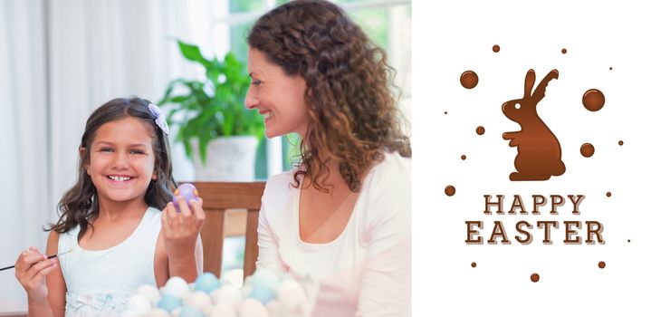 Happy mother and daughter painting easter eggs  against happy easter graphic