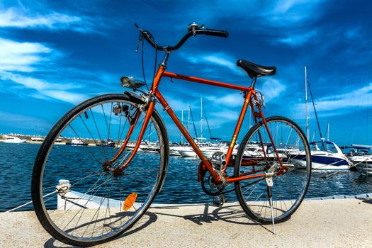 Orange bike with marina background.
