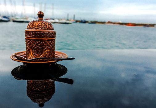 Bronze oriental cup of coffee with motifs.