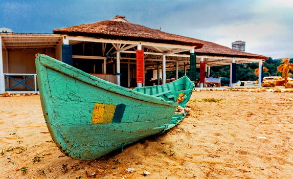 Green wrecked boat on the sand beach.