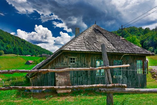 Mountain landscape with old wooden house.