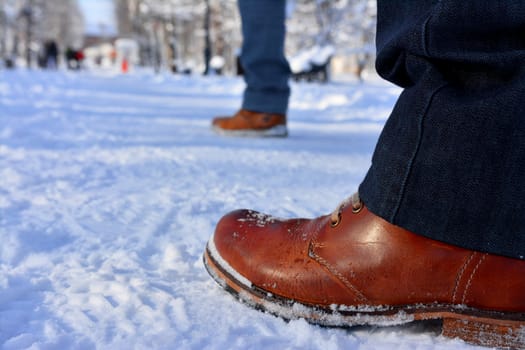 Close up winter shoes on snow.