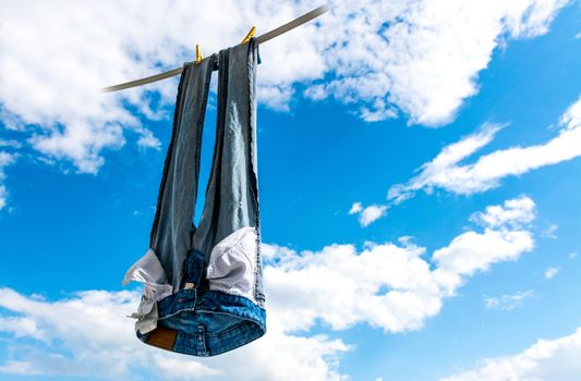 Blue jeans hung to dry in the sky.