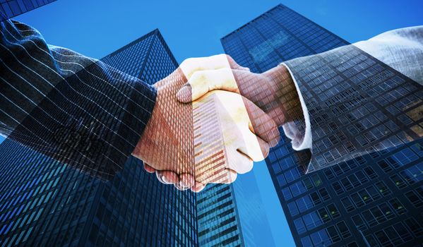 Business people shaking hands against skyscraper