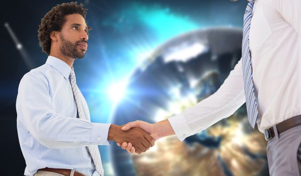 Young businessmen shaking hands in office against earth seen from space