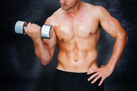 Bodybuilder lifting dumbbell against black background