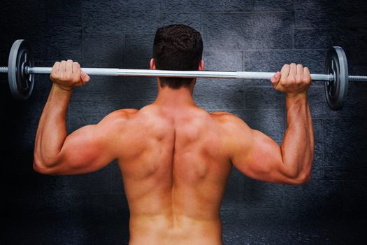 Bodybuilder lifting barbell against black background