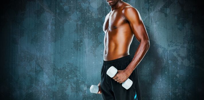 Mid section of fit shirtless man lifting dumbbells against blue paint splashed surface