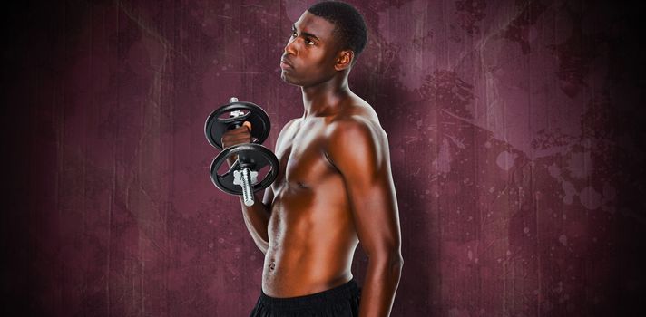 Serious fit shirtless young man lifting dumbbell against red paint splashed surface