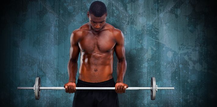 Fit man lifting barbell against blue paint splashed surface