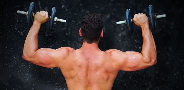 Bodybuilder lifting dumbbells against black background