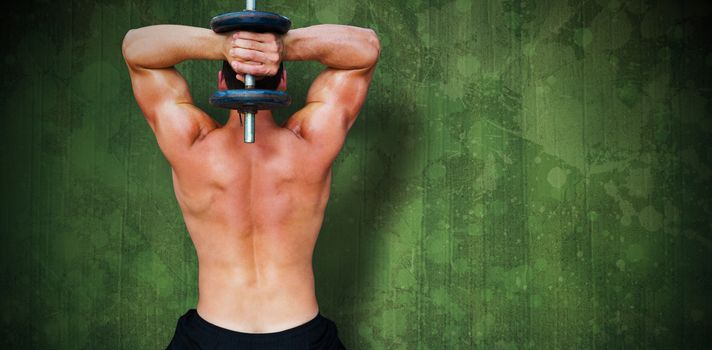 Bodybuilder lifting dumbbell against green paint splashed surface