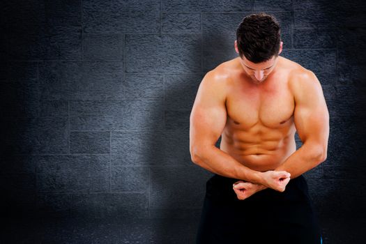 Bodybuilder posing against black background