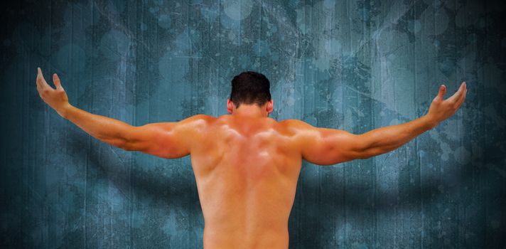 Bodybuilder posing against blue paint splashed surface