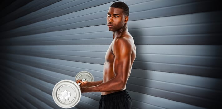 Portrait of a serious fit young man lifting barbell against grey shutters