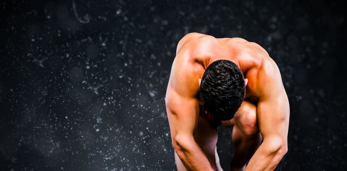 Bodybuilder posing against black background