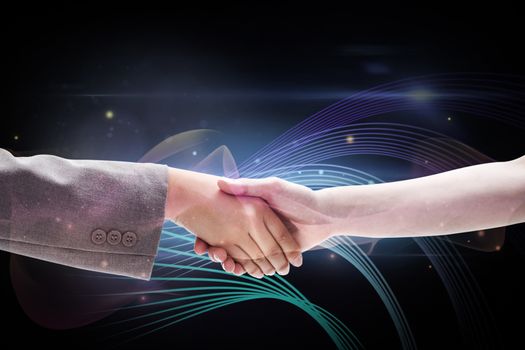 Handshake between two women against futuristic glowing lines on black background