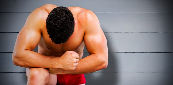 Bodybuilder posing against painted blue wooden planks