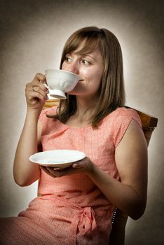 Woman sitting on a chair and drinking tea or coffee