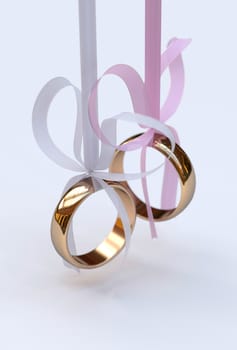 Couple of gold wedding rings with bows on white background