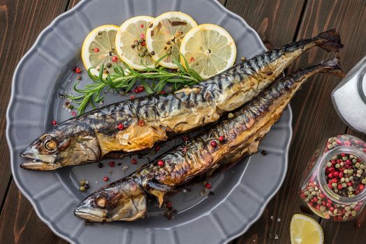 Baked Whole Mackerel Fish with Spice, Lemon and Rosemary on a Plate on Wooden Table