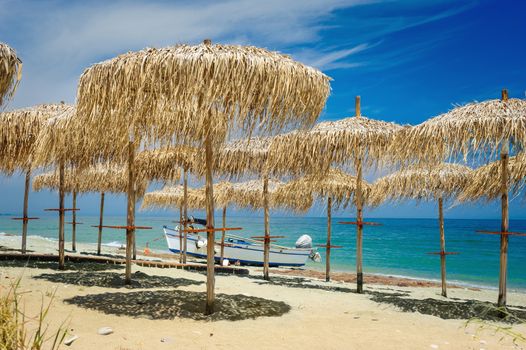 Rows of reed umbrellas on the sea beach 