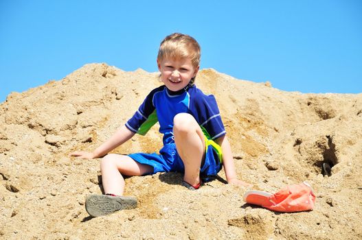 boy playing in sand on the beach