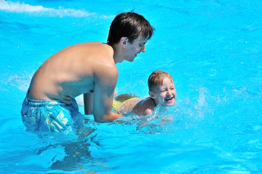 father teaching his little son to swim, they are happy