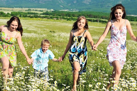 happy children running in the daisy field