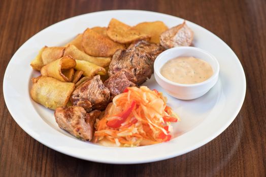 Grilled pork, baked potatoes and vegetable salad