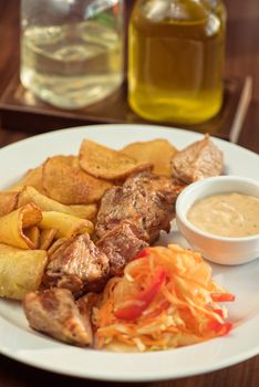 Grilled pork, baked potatoes and vegetable salad