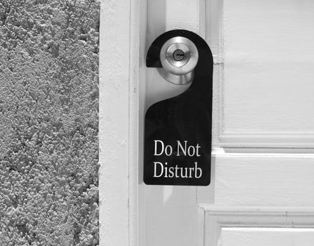 Do not disturb sign hang on door knob and stone wall.