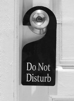 Do not disturb sign hang on door knob and stone wall.