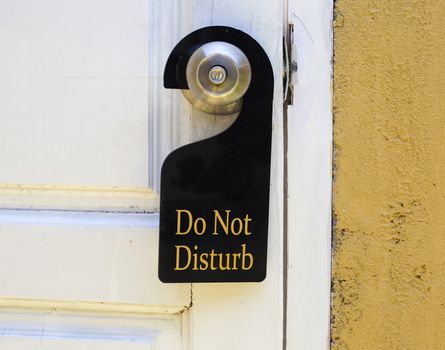 Do not disturb sign hang on door knob and stone wall.