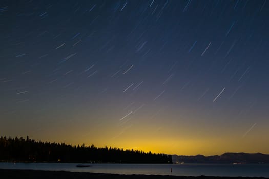 Star trails over the colors of the setting sun in Lake Tahoe, CA.