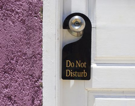 Do not disturb sign hang on door knob and stone wall.