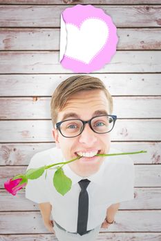 Geeky hipster holding a red rose in his teeth against wooden planks