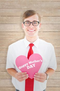 Geeky hipster holding heart card against wooden planks