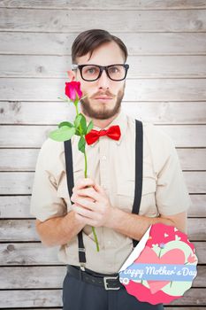 Geeky hipster offering a rose against wooden planks