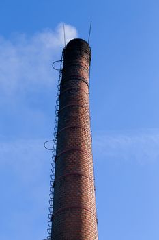 Polluting white smoke coming out of chimney against blue sky
