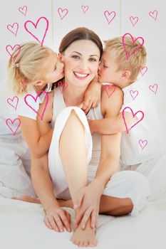 Adorable siblings kissing their mother sitting on a bed against red hearts