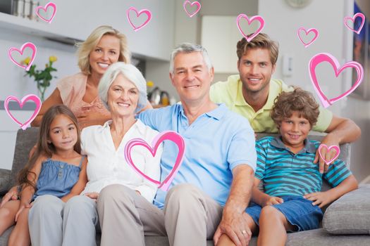 Multigeneration family posing in the living room against red hearts