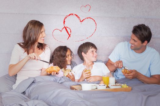 Family having breakfast in bed against heart