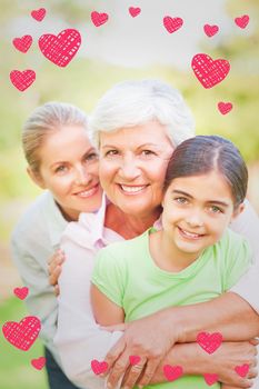 Adorable family in the park against red hearts