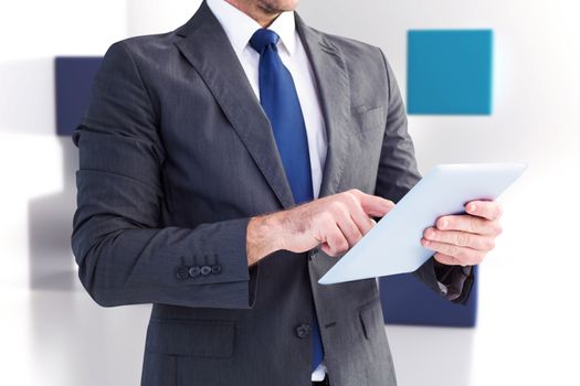 Businessman using his tablet pc  against abstract background