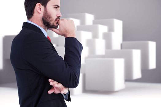 Thinking businessman standing with hand on chin against abstract background