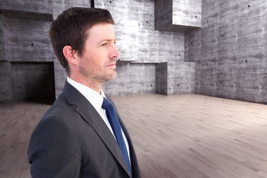 Handsome businessman looking away against abstract room