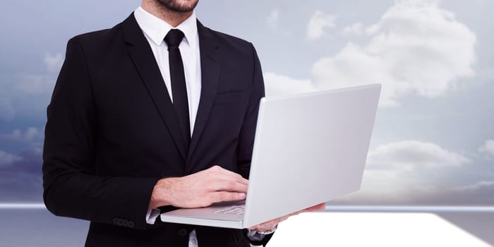Mid section of a businessman using laptop against clouds in a room